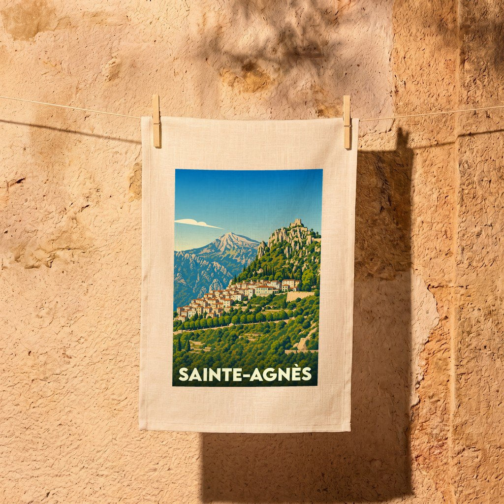 Torchon souvenir de la ville de Sainte-Agnès orné d'une illustration stylisée de son village perché.