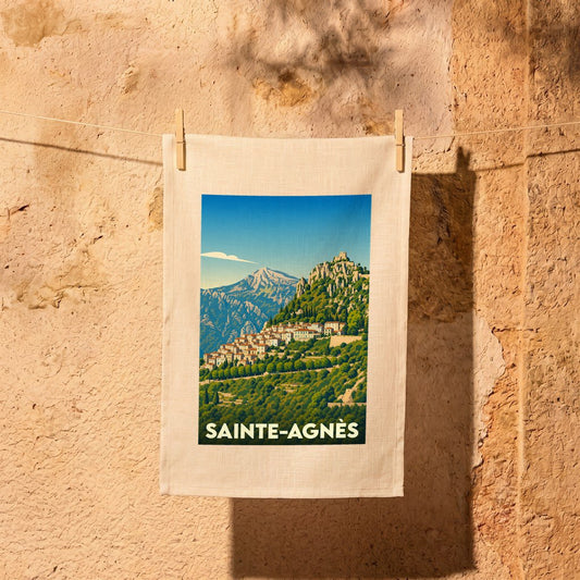 Torchon souvenir de la ville de Sainte-Agnès orné d'une illustration stylisée de son village perché.