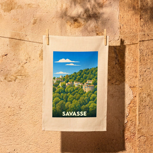 Torchon souvenir de la ville de Savasse avec une illustration stylisée d'un village perché dans la forêt.