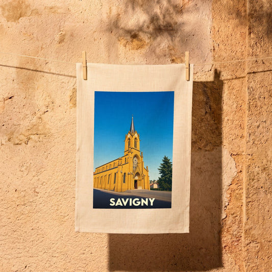 Torchon souvenir de la ville de Savigny illustré par une église stylisée sur fond de ciel bleu.
