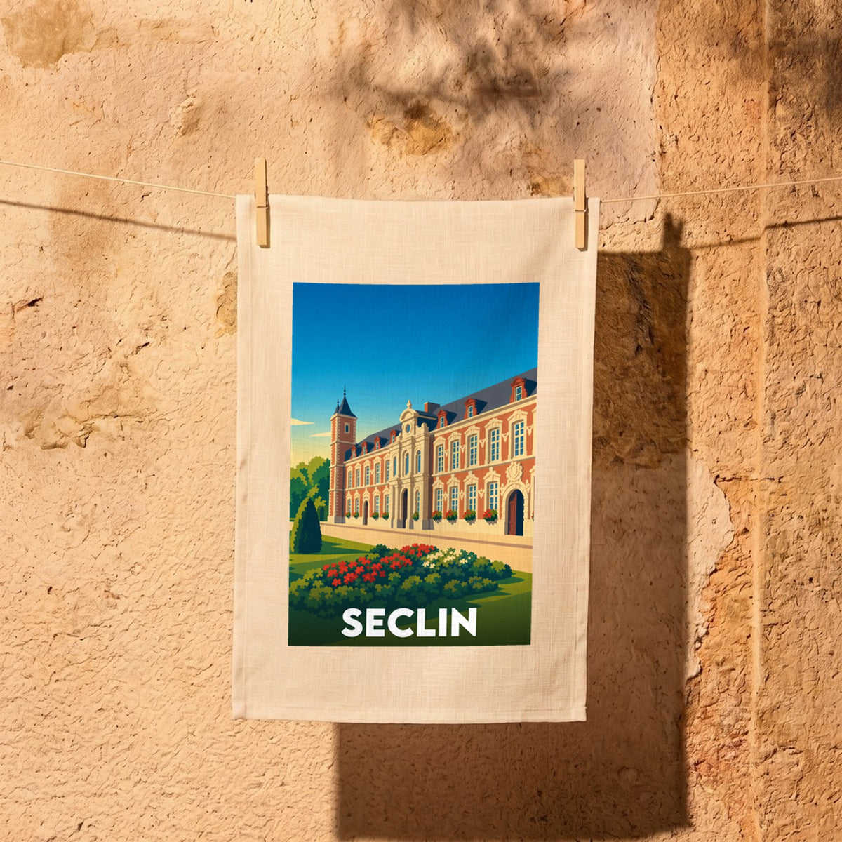 Torchon souvenir de la ville de Seclin avec une illustration stylisée d'un bâtiment historique en briques rouges.