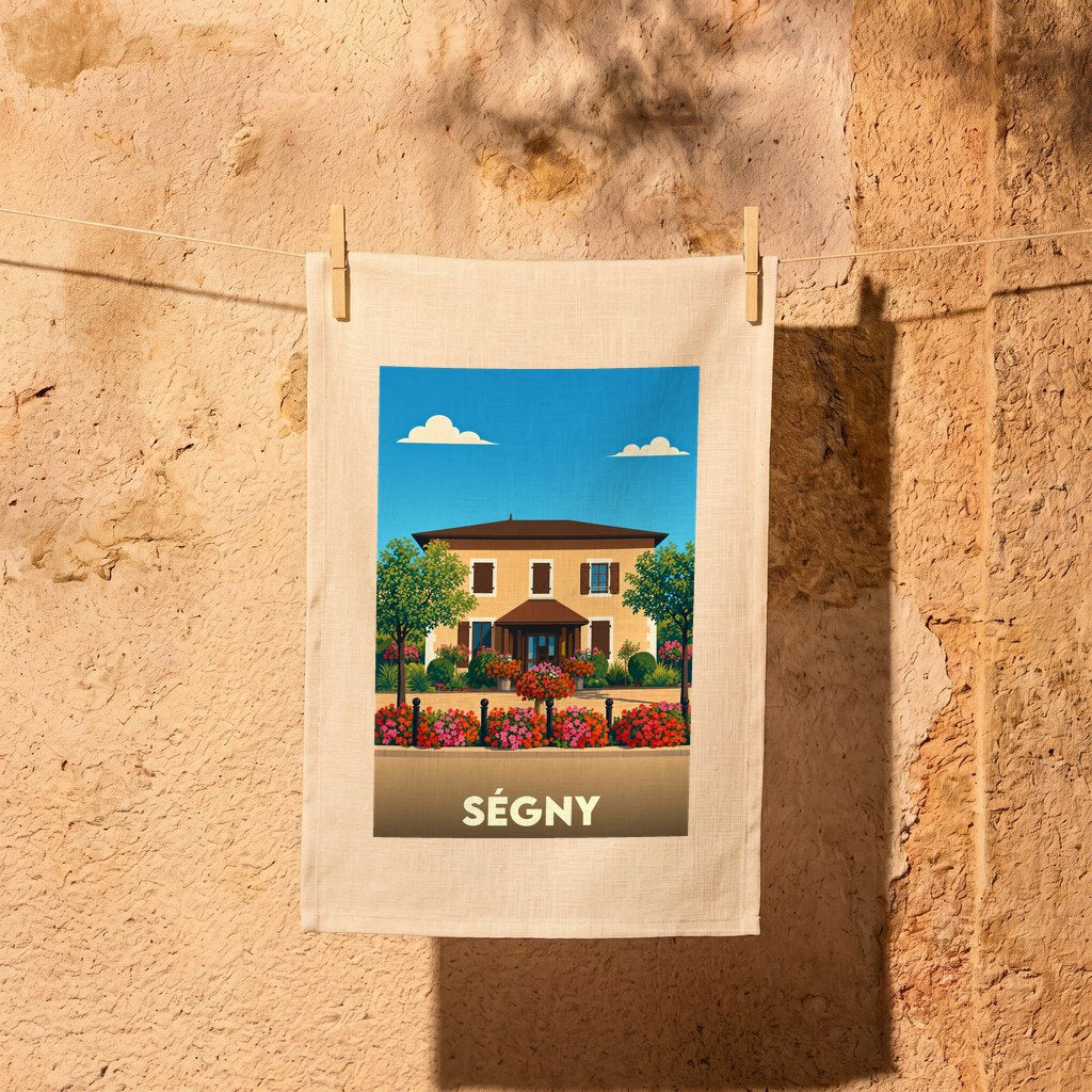 Torchon souvenir de la ville de Ségny avec une illustration stylisée d'une maison fleurie.