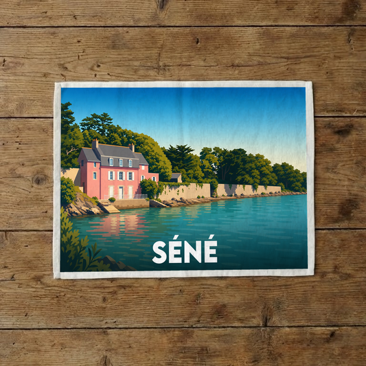 Torchon souvenir de la ville de Séné avec une illustration stylisée d'une maison rose en bord de mer.