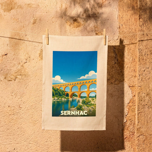 Torchon souvenir de la ville de Sernhac illustré d'un paysage stylisé du Pont du Gard.