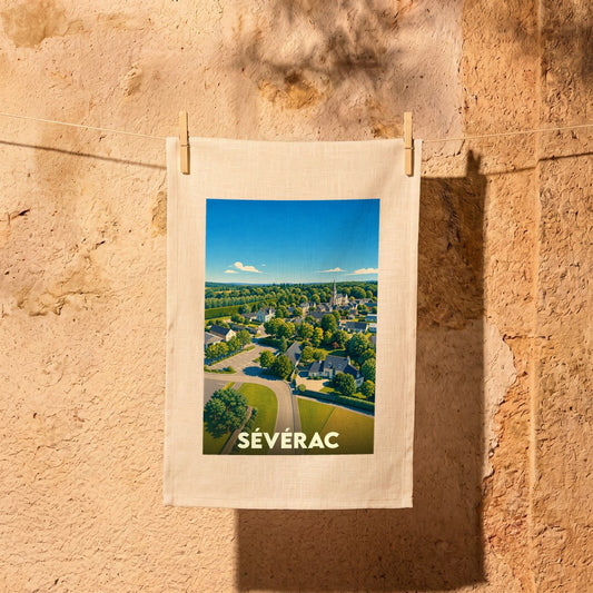 Torchon de cuisine souvenir de la ville de Sévérac illustré d'une vue aérienne stylisée du village.