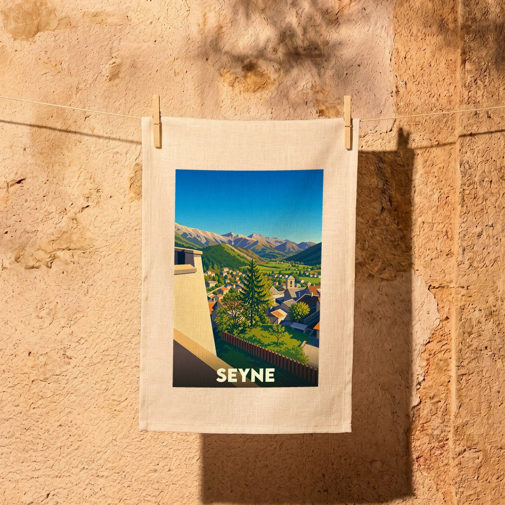 Torchon souvenir de la ville de Seyne orné d'une illustration panoramique colorée de la commune et de ses montagnes.