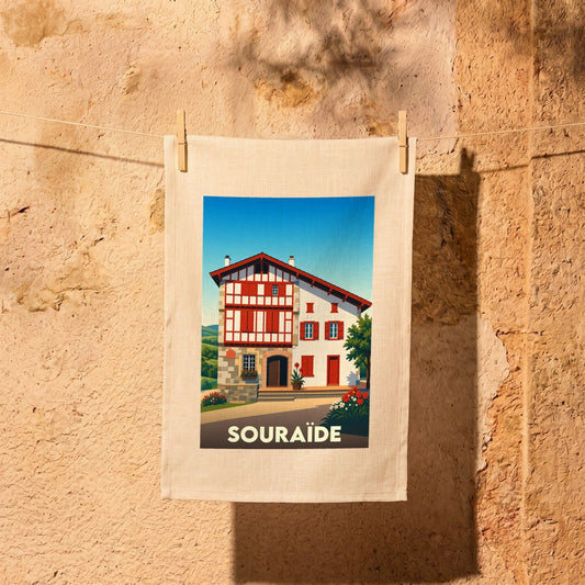 Torchon souvenir de la ville de Souraïde illustré d'une maison basque traditionnelle typique.