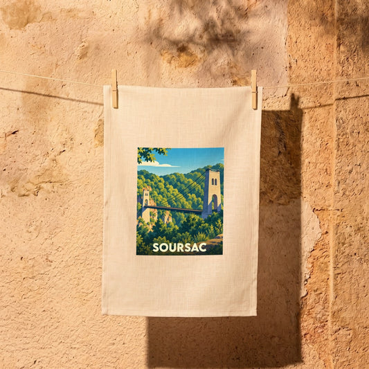 Torchon souvenir de la ville de Soursac illustré par une vue stylisée de son pont suspendu.