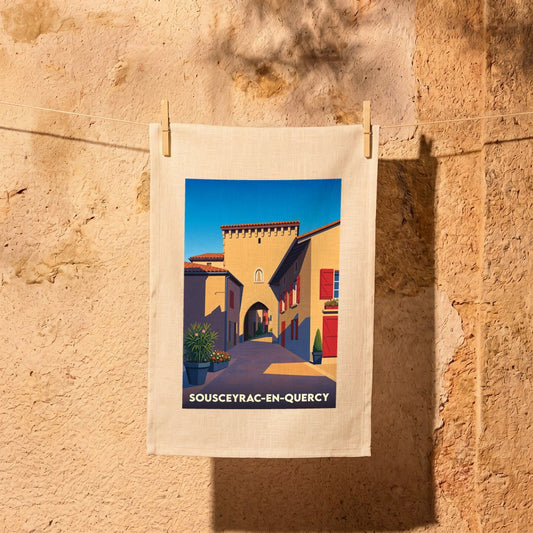 Torchon souvenir de la ville de Sousceyrac-en-Quercy avec une illustration stylisée d'une ruelle historique.