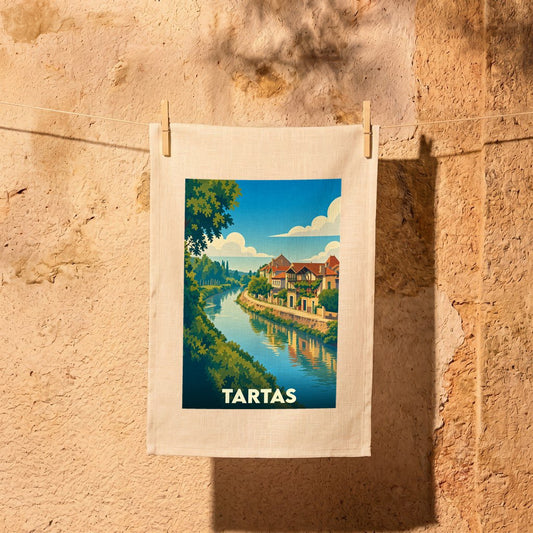 Torchon souvenir de la ville de Tartas avec une illustration stylisée d'un paysage fluvial.