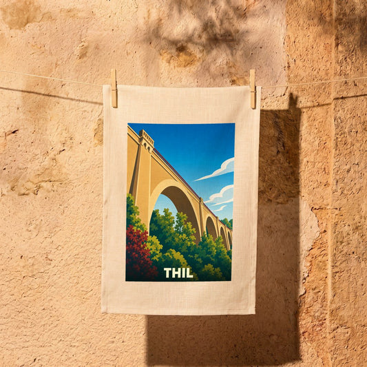 Torchon souvenir de la ville de Thil avec une illustration stylisée représentant un viaduc.