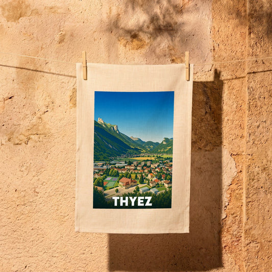 Torchon souvenir de la ville de Thyez illustré d'un paysage de montagne stylisé.