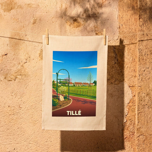 Torchon souvenir de la ville de Tillé illustré par un paysage de village stylisé.