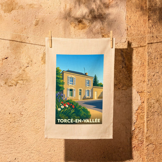 Torchon souvenir de la ville de Torcé-en-Vallée avec une illustration stylisée d'une maison ensoleillée.