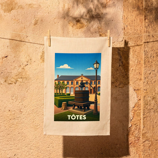 Torchon souvenir de la ville de Tôtes avec une illustration stylisée d'un pressoir à pomme devant une bâtisse.