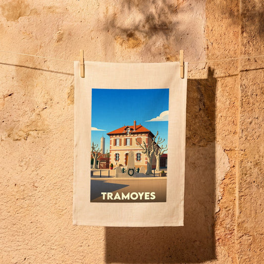 Torchon souvenir de la ville de Tramoyes avec une illustration stylisée d'une place ensoleillée.