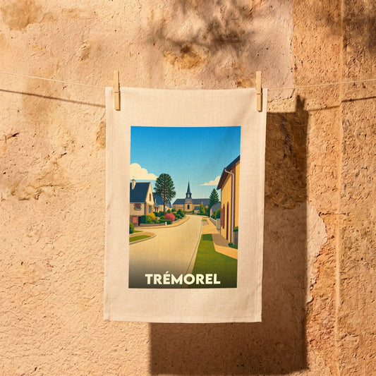 Torchon souvenir de la ville de Trémorel avec une illustration stylisée d'une rue du village menant à l'église.