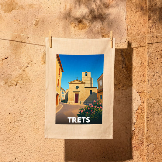 Torchon souvenir de la ville de Trets illustrant son église provençale sous un ciel bleu azur.