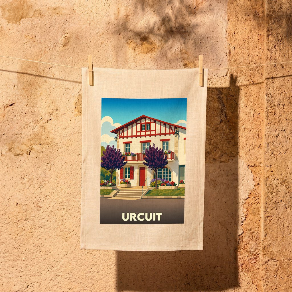 Torchon souvenir de la ville de Urcuit avec une illustration stylisée d'une maison basque traditionnelle.