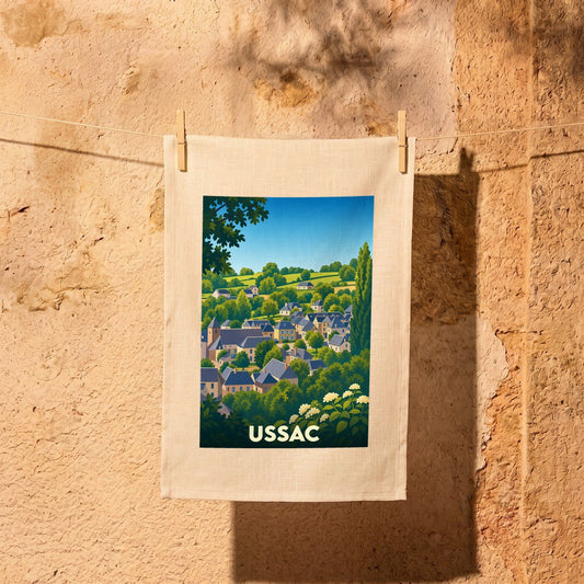 Torchon souvenir de la ville d'Ussac avec une illustration stylisée d'un village vallonné.