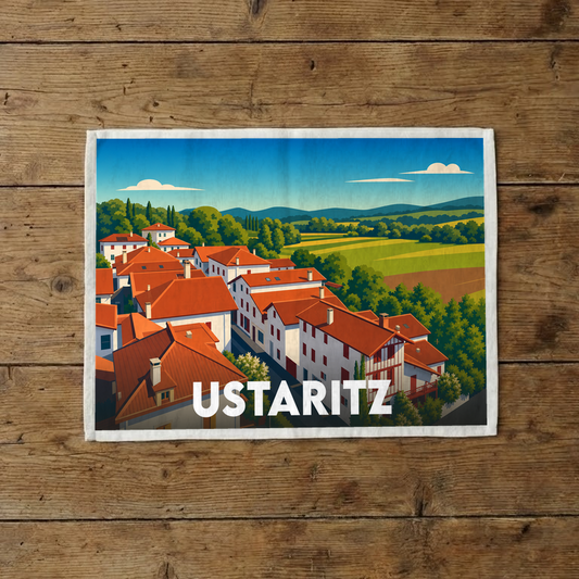 Torchon souvenir de la ville d'Ustaritz orné d'une illustration stylisée représentant un paysage basque typique.