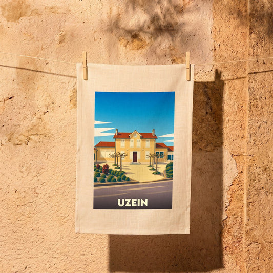 Torchon souvenir de la ville de Uzein avec une illustration stylisée d'un bâtiment emblématique sous un ciel bleu.
