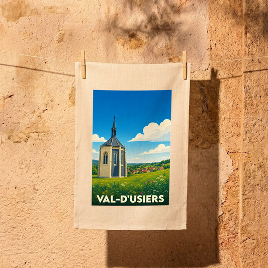Torchon souvenir de la ville de Val-d'Usiers avec une illustration stylisée d'une chapelle dans un paysage verdoyant.