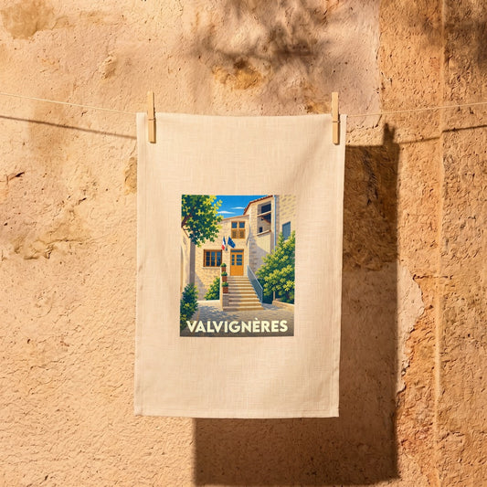 Torchon souvenir de la ville de Valvignères avec une illustration stylisée d'une ruelle ensoleillée.
