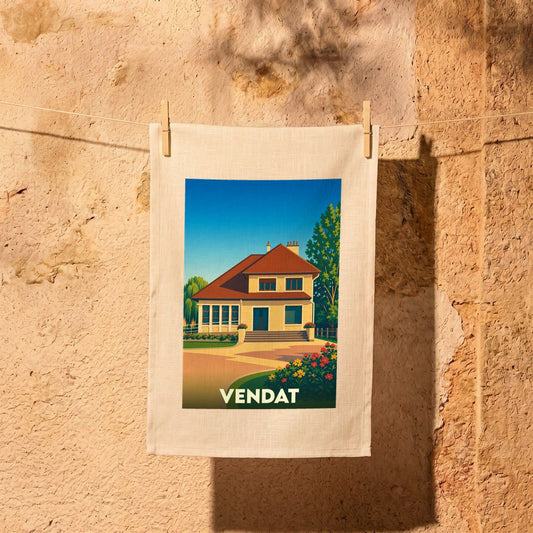 Torchon souvenir de la ville de Vendat illustré d'une maison de style traditionnel sous un ciel bleu.