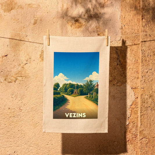 Torchon souvenir de la ville de Vezins illustré par un paysage champêtre stylisé.