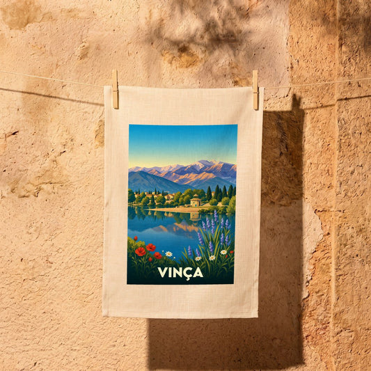 Torchon souvenir de la ville de Vinça illustrant un paysage de lac et de montagnes au style vintage.