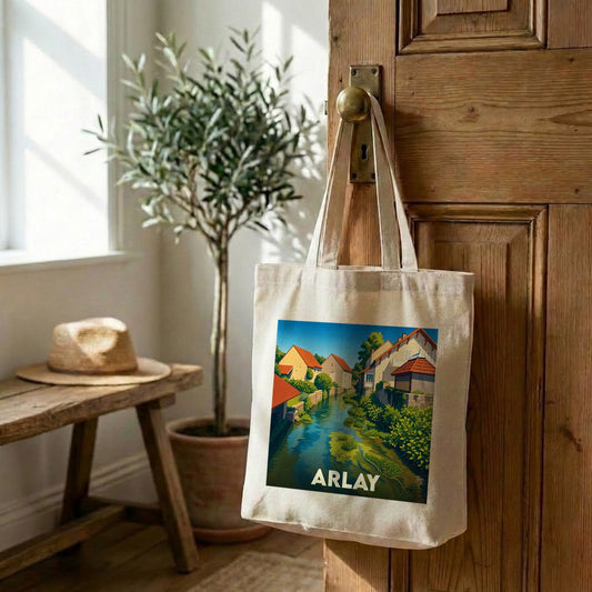 Tote bag souvenir de la ville d'Arlay avec une illustration colorée et stylisée d'un canal bordé de maisons.