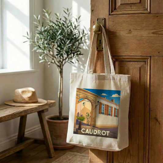 Tote bag souvenir de la ville de Caudrot avec une illustration stylisée d'une rue ensoleillée.