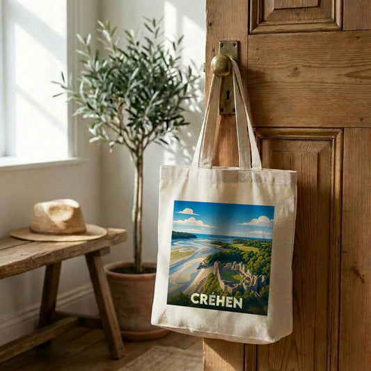 Tote bag souvenir de la ville de Créhen avec une illustration stylisée d'un paysage côtier et médiéval.