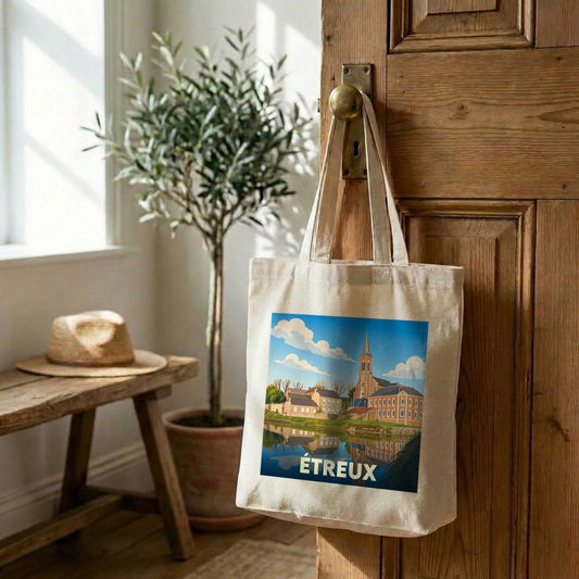 Tote bag souvenir de la ville d'Étreux avec une illustration stylisée d'un paysage urbain au bord de l'eau.