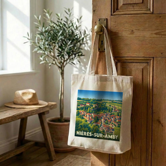 Tote bag souvenir de la ville de Hières-sur-Amby avec une illustration stylisée d'un village niché dans la verdure.