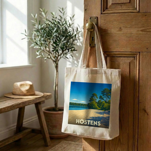 Tote bag souvenir de la ville de Hostens avec une illustration stylisée de sa plage et de sa forêt.