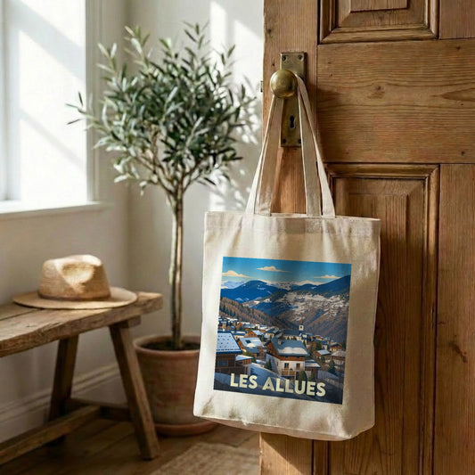 Tote bag souvenir de la ville de Les Allues avec une illustration stylisée d'un village de montagne enneigé.