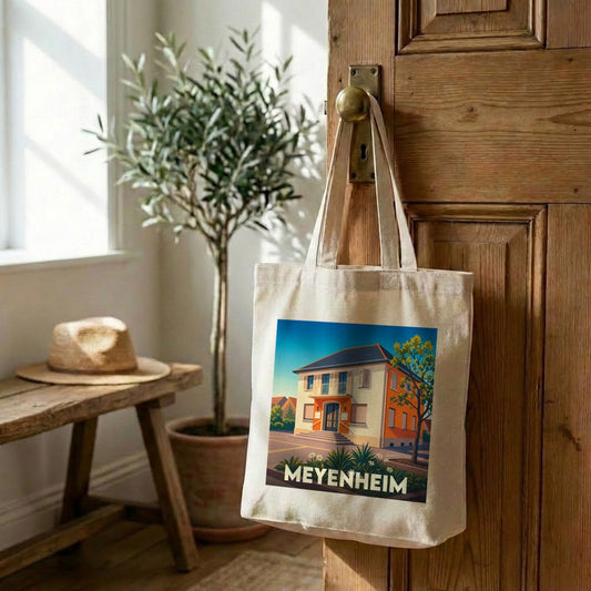 Tote bag souvenir de la ville de Meyenheim avec une illustration stylisée d'une maison traditionnelle.