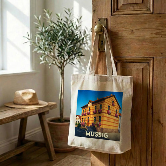 Tote bag souvenir de la ville de Mussig avec une illustration stylisée d'un bâtiment alsacien fleuri.