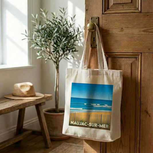 Tote bag souvenir de Naujac-sur-Mer avec une illustration stylisée d'une plage et de l'océan.
