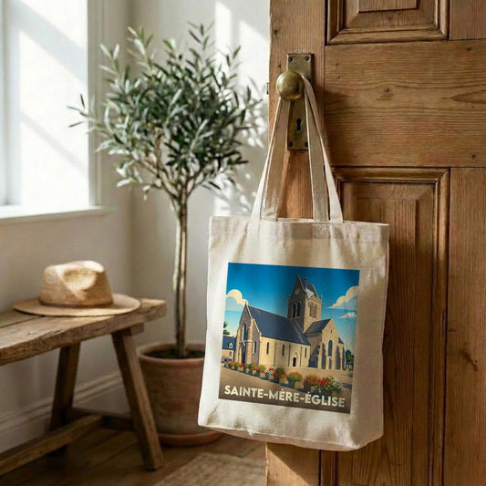Tote bag souvenir de la ville de Sainte-Mère-Église avec une illustration stylisée de son église.